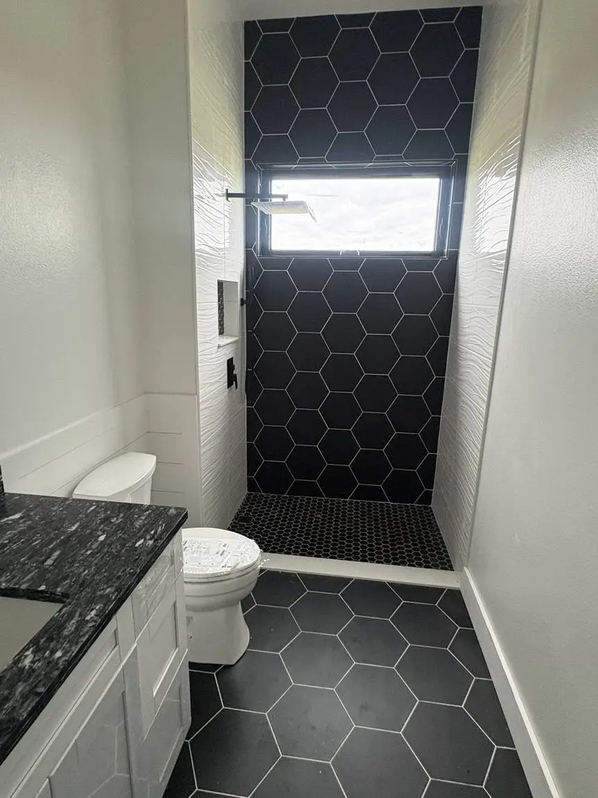 Black hexagon tile shower with textured white feature walls and black hex floor tile, Lakeland FL