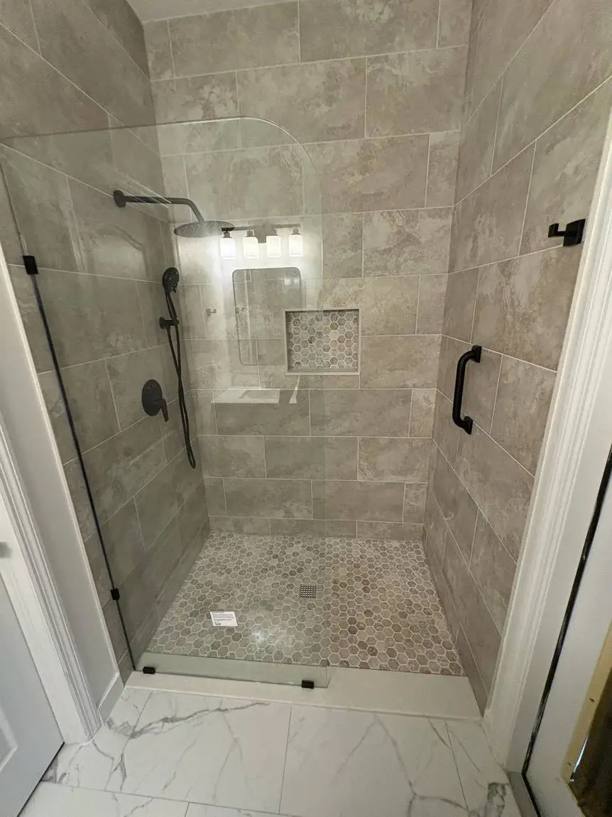 Frameless glass shower with recessed niche and hex mosaic floor, Brandon FL bathroom remodel