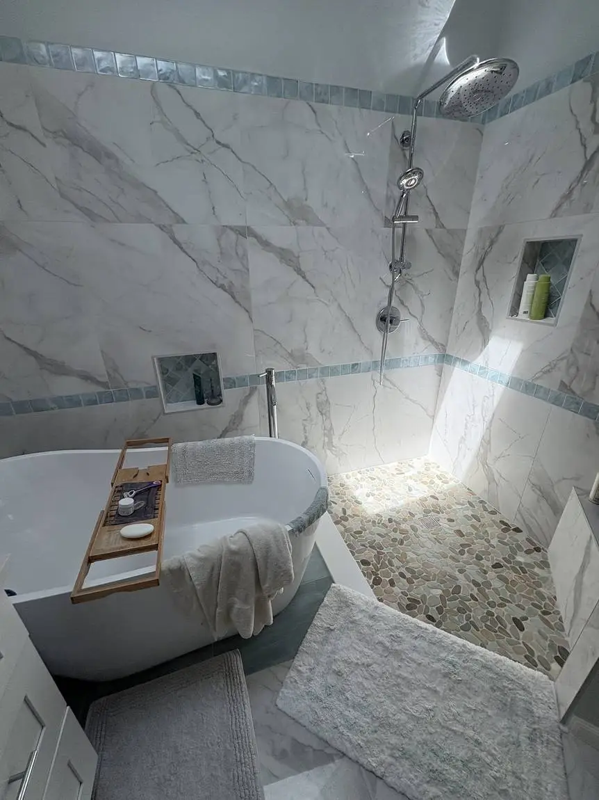 Freestanding soaking tub beside a walk-in shower with a river rock floor, Lakeland FL bathroom