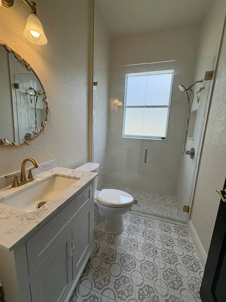 Guest bathroom with patterned floor tile, stacked white shower tile and brushed gold fixtures, Valrico FL