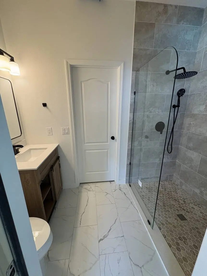 Walk-in shower with large-format porcelain walls and hex mosaic floor in a Brandon, FL bathroom remodel