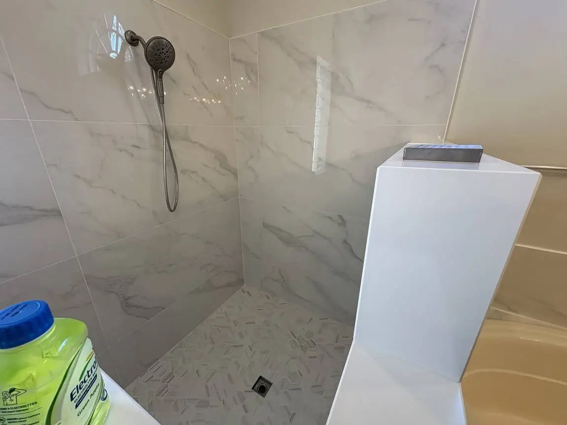 Walk-in shower with marble-look porcelain walls and picket mosaic floor, Brandon FL