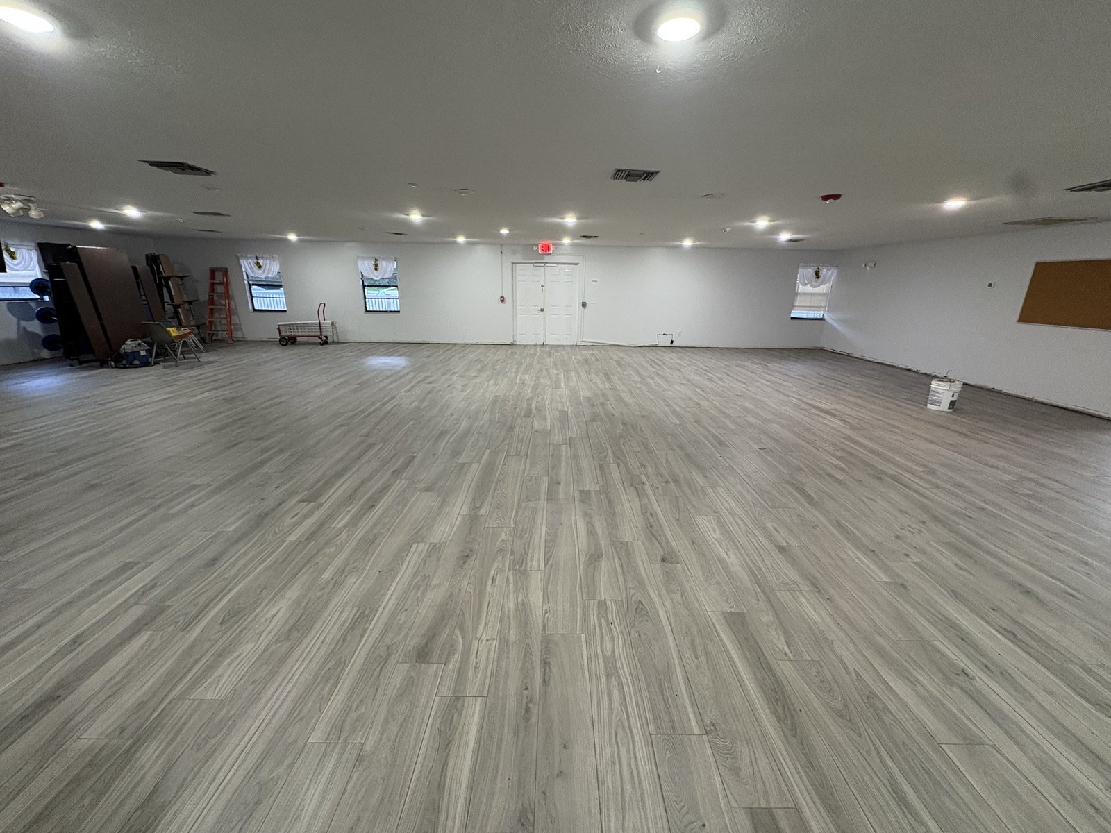 Wood-look plank flooring installed wall to wall over crack isolation membrane in a Plant City church fellowship hall